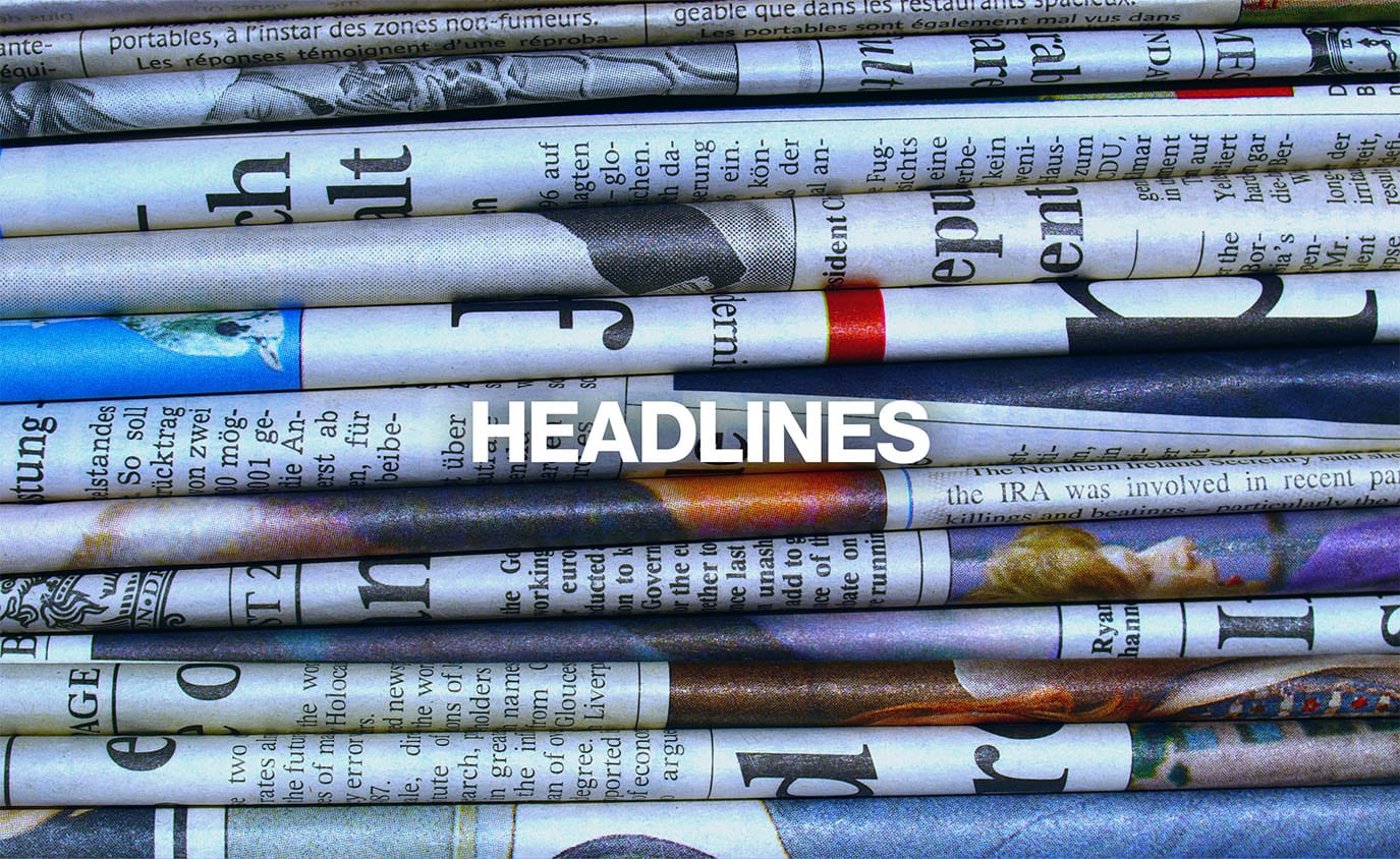 News Headlines - newspapers stacked behind headlines text