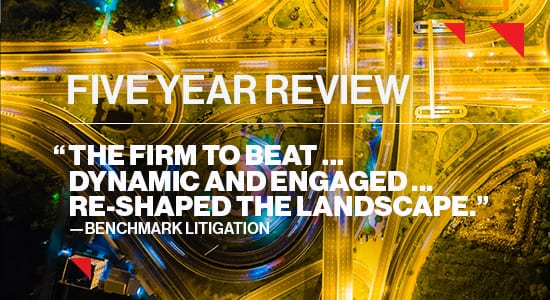 Aerial view of highway at night with text over-layed: Five Year Review "The firm to beat... Dynamic and Engage... Shaped the Landscape" -- Benchmark Litigation